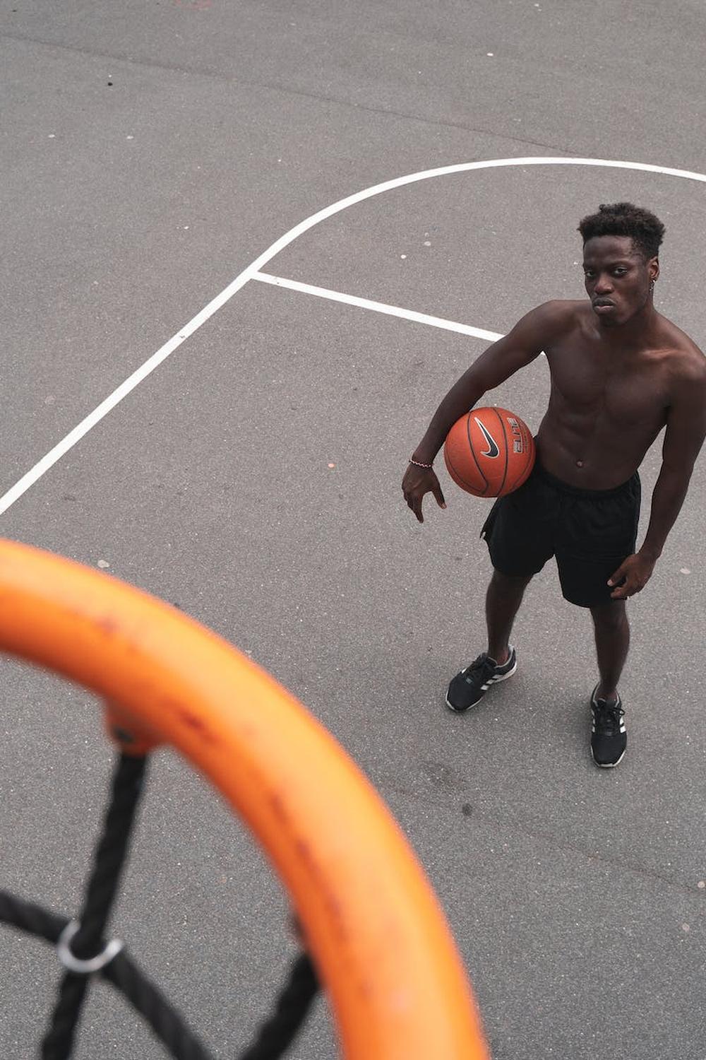 man_standing_near_basketball_hoop_holding_a_basket
