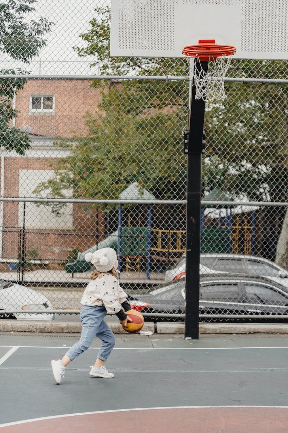 unrecognizable_girl_playing_basketball_on_sports_g